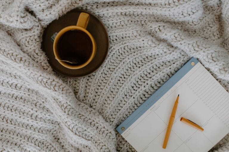 A journal beside a warm cup of tea on a softly lit desk, symbolizing reflection, self-discovery, and peaceful morning clarity.